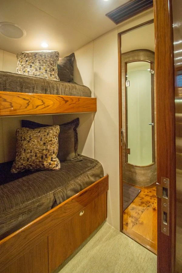 The cozy guest cabin features bunk beds with plush pillows and a private en-suite bathroom. aboard REMAIN CALM Yacht for Sale