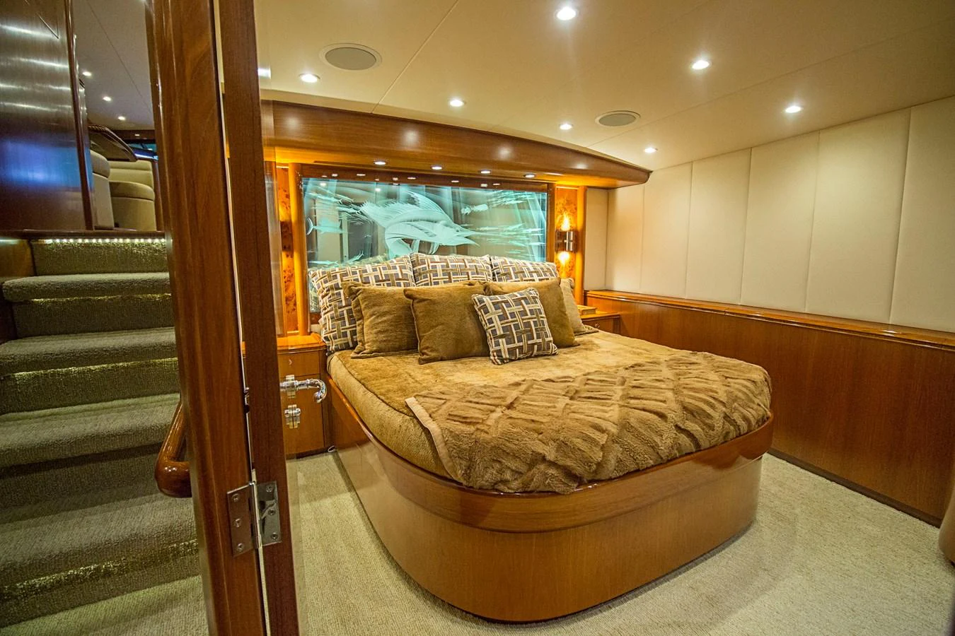 The master stateroom features a luxurious bed with plush bedding and warm wood accents. aboard REMAIN CALM Yacht for Sale