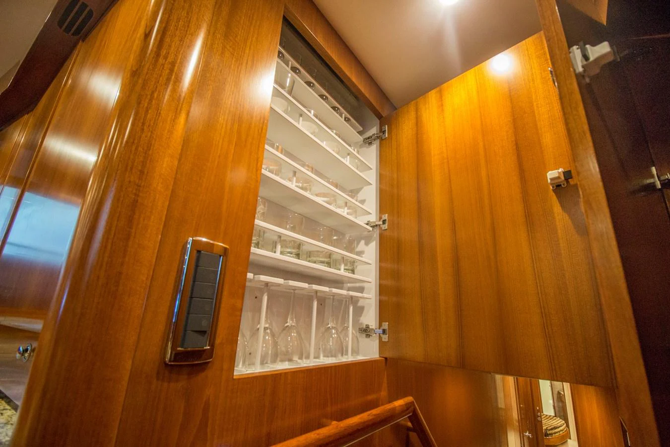 The image showcases a well-organized glassware storage cabinet within the yacht's interior. aboard REMAIN CALM Yacht for Sale