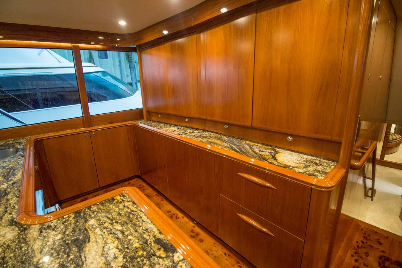 The yacht's galley features elegant wood cabinetry and luxurious granite countertops. aboard REMAIN CALM Yacht for Sale