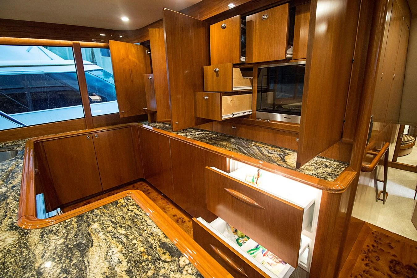 The galley features rich wood cabinetry and luxurious granite countertops, creating an elegant and functional space. aboard REMAIN CALM Yacht for Sale
