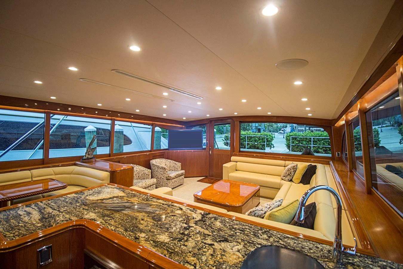The yacht's salon features luxurious seating, a granite countertop, and ample natural light through large windows. aboard REMAIN CALM Yacht for Sale