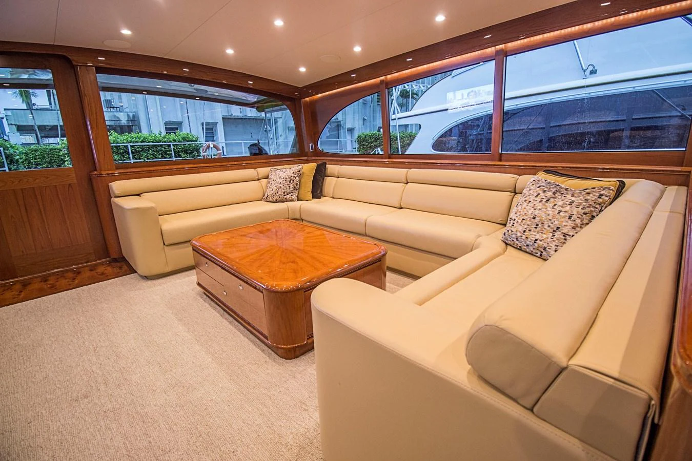 The salon features a spacious and elegant seating area with plush beige sofas and a polished wooden coffee table. aboard REMAIN CALM Yacht for Sale