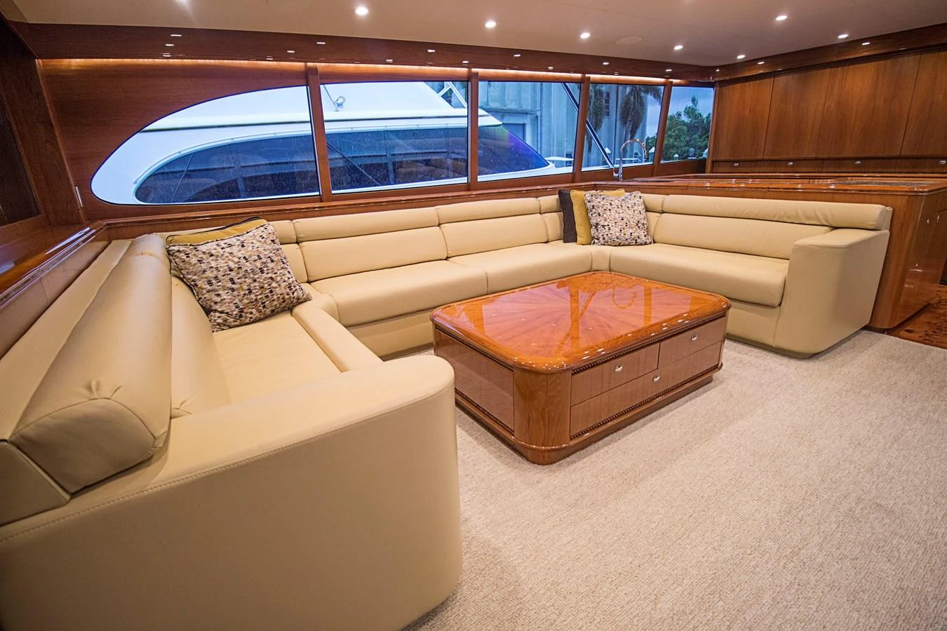 The salon features plush beige seating and elegant wooden accents, creating a warm and inviting atmosphere. aboard REMAIN CALM Yacht for Sale