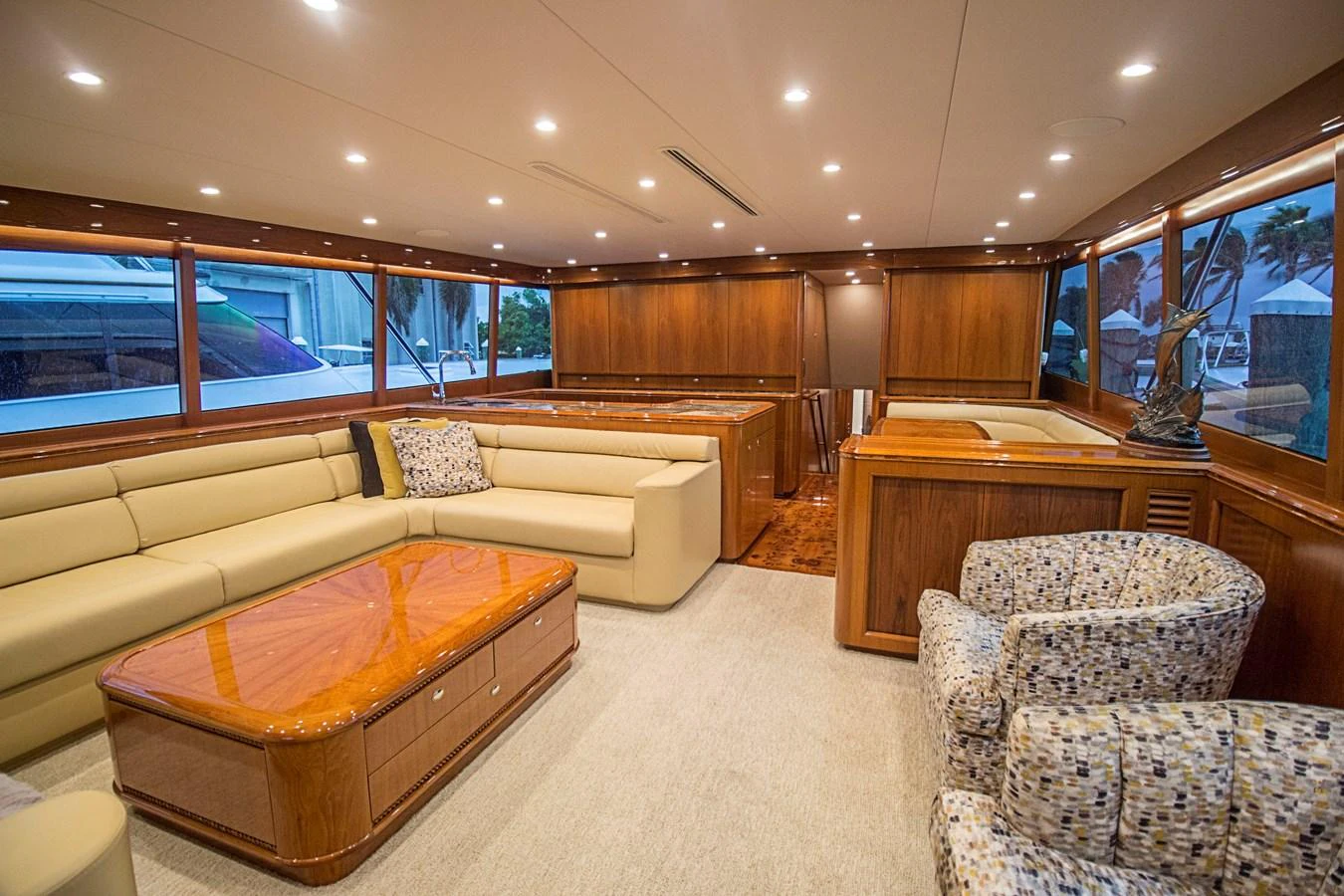 The salon features luxurious seating with ample natural light and elegant wooden finishes. aboard REMAIN CALM Yacht for Sale