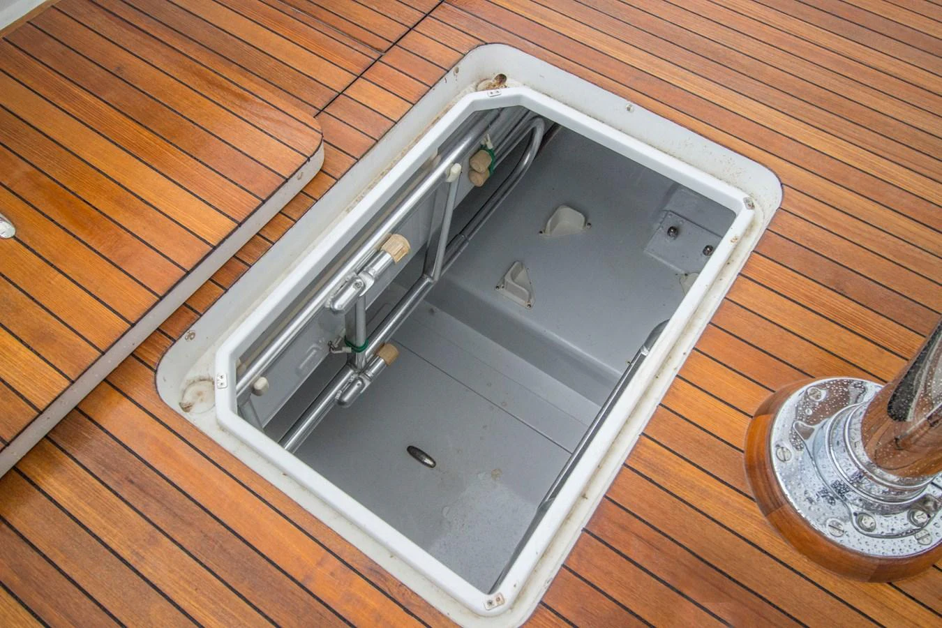 A detailed view of a hatch on the yacht's deck, showcasing the quality of the woodwork and the access to the storage compartment below. aboard REMAIN CALM Yacht for Sale