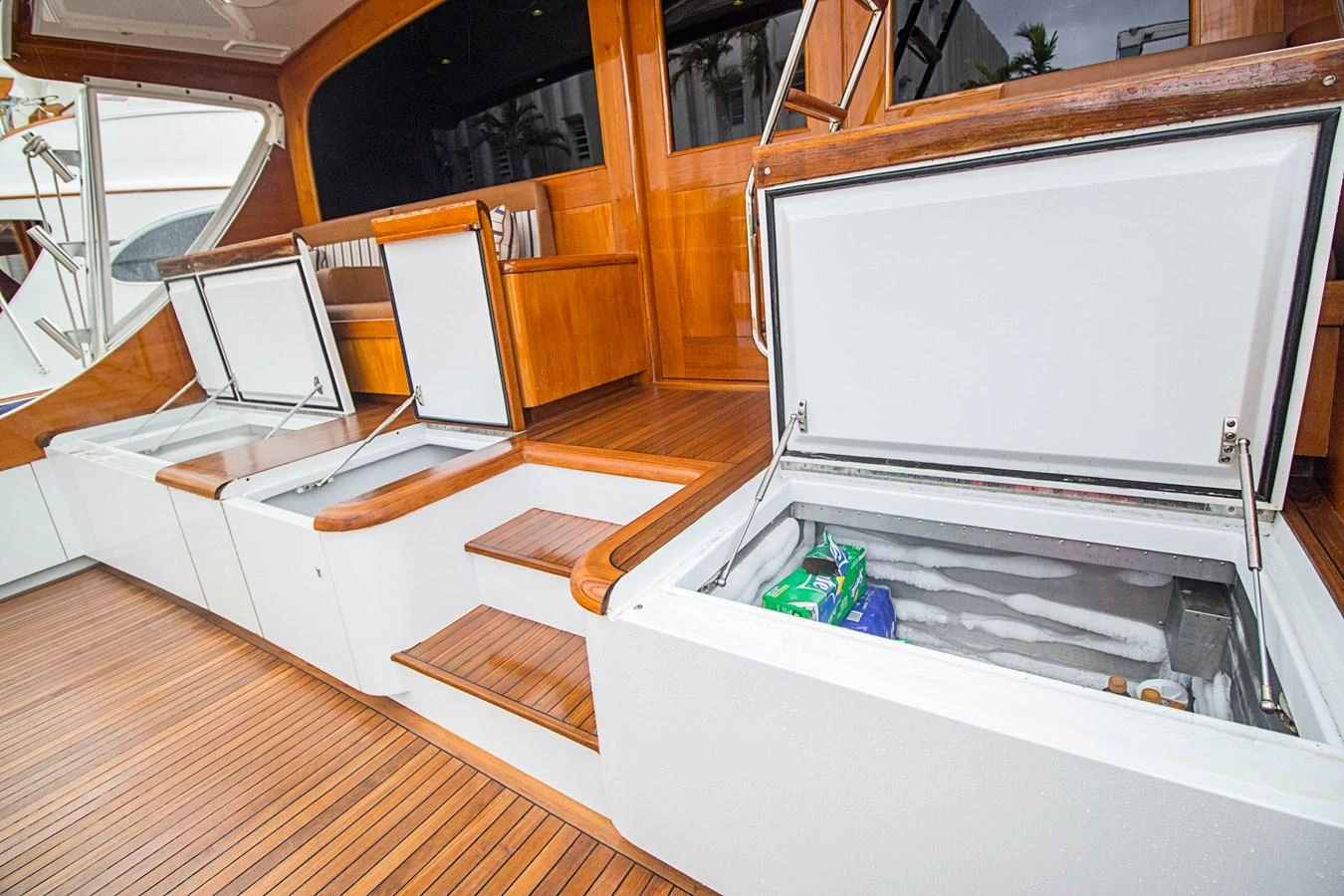 The yacht features spacious deck storage compartments with wooden steps and sleek finishes. aboard REMAIN CALM Yacht for Sale