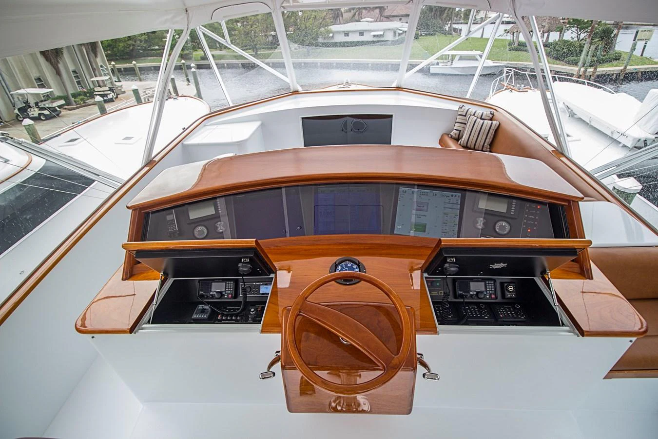 The helm station features state-of-the-art navigation equipment and a sleek wooden steering wheel. aboard REMAIN CALM Yacht for Sale