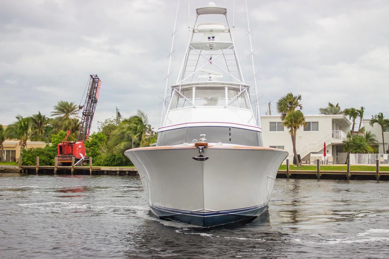 A sleek yacht is docked in a calm marina, showcasing its impressive bow and multi-level structure. aboard REMAIN CALM Yacht for Sale