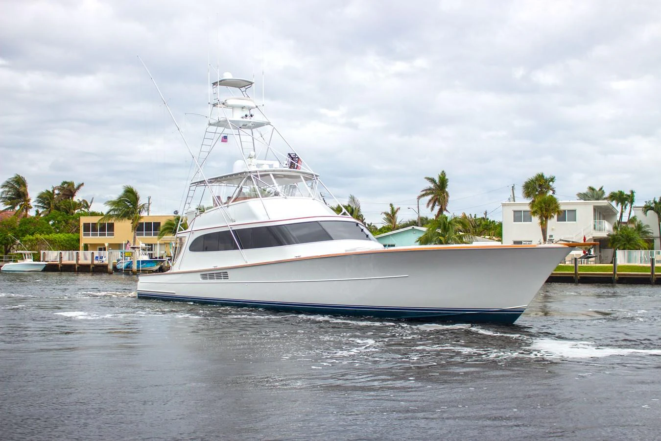 A sleek yacht cruises through a calm waterway, showcasing its elegant design and modern lines. aboard REMAIN CALM Yacht for Sale