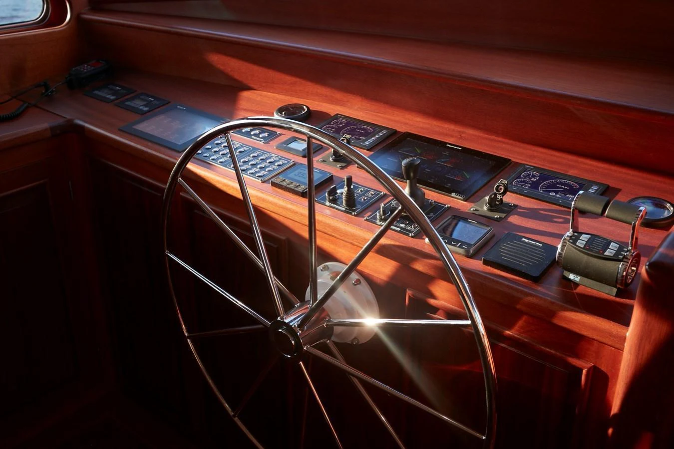 The helm station features a classic wooden steering wheel and an array of navigational instruments. aboard WHITE WINGS Yacht for Sale