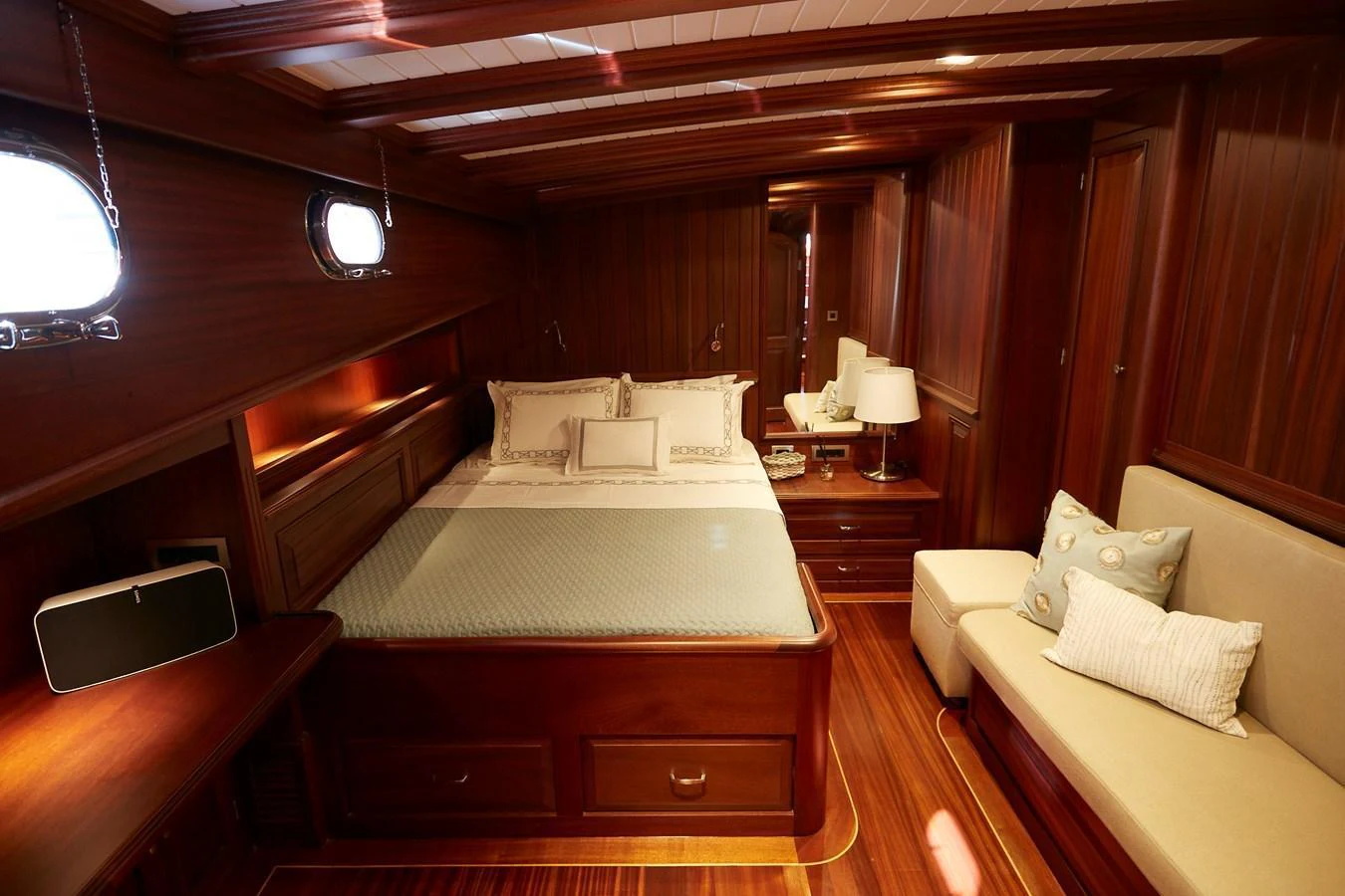 The stateroom features a luxurious bed with elegant wood paneling and soft ambient lighting. aboard WHITE WINGS Yacht for Sale