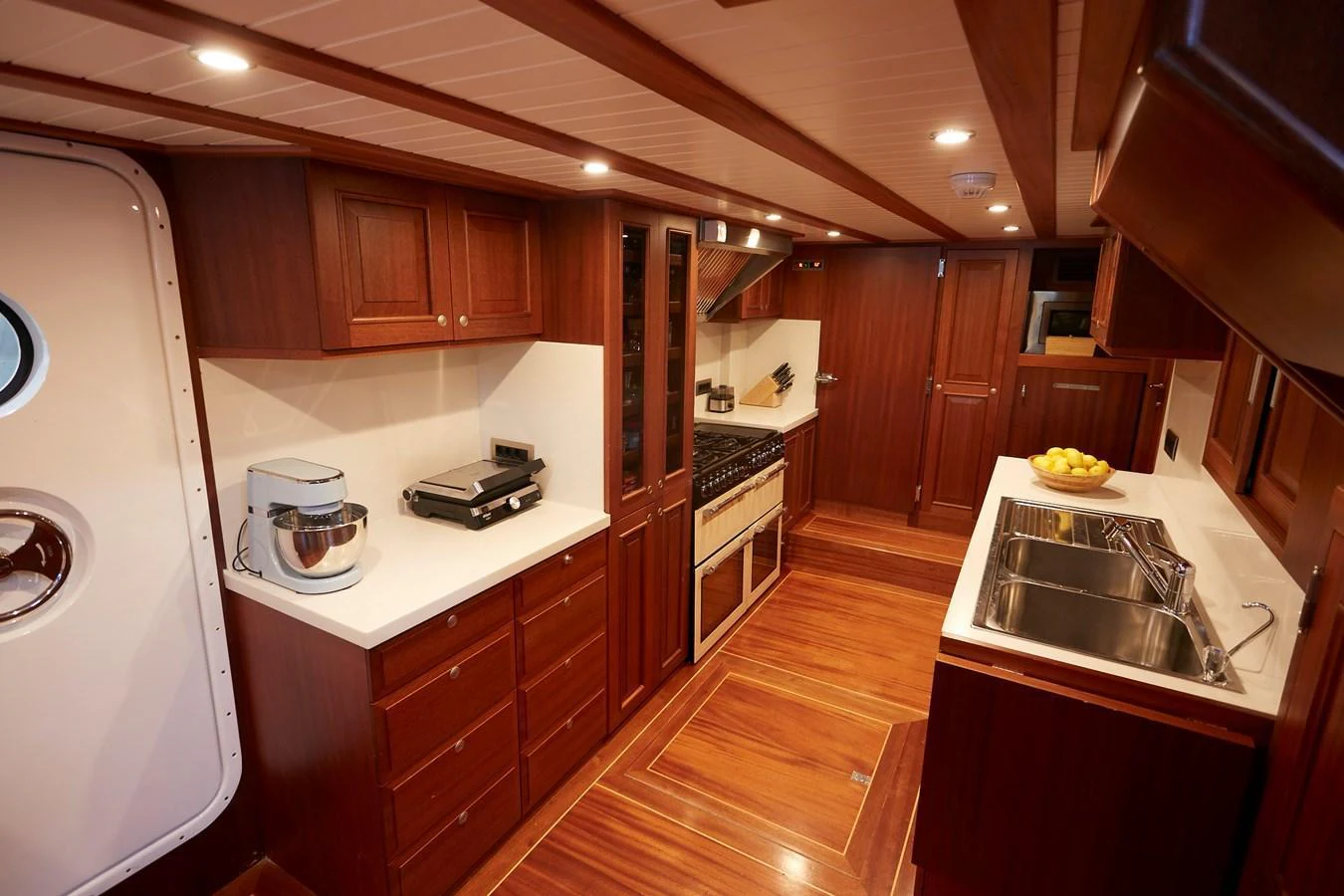 The galley features rich wood cabinetry, modern appliances, and ample counter space for culinary preparation. aboard WHITE WINGS Yacht for Sale