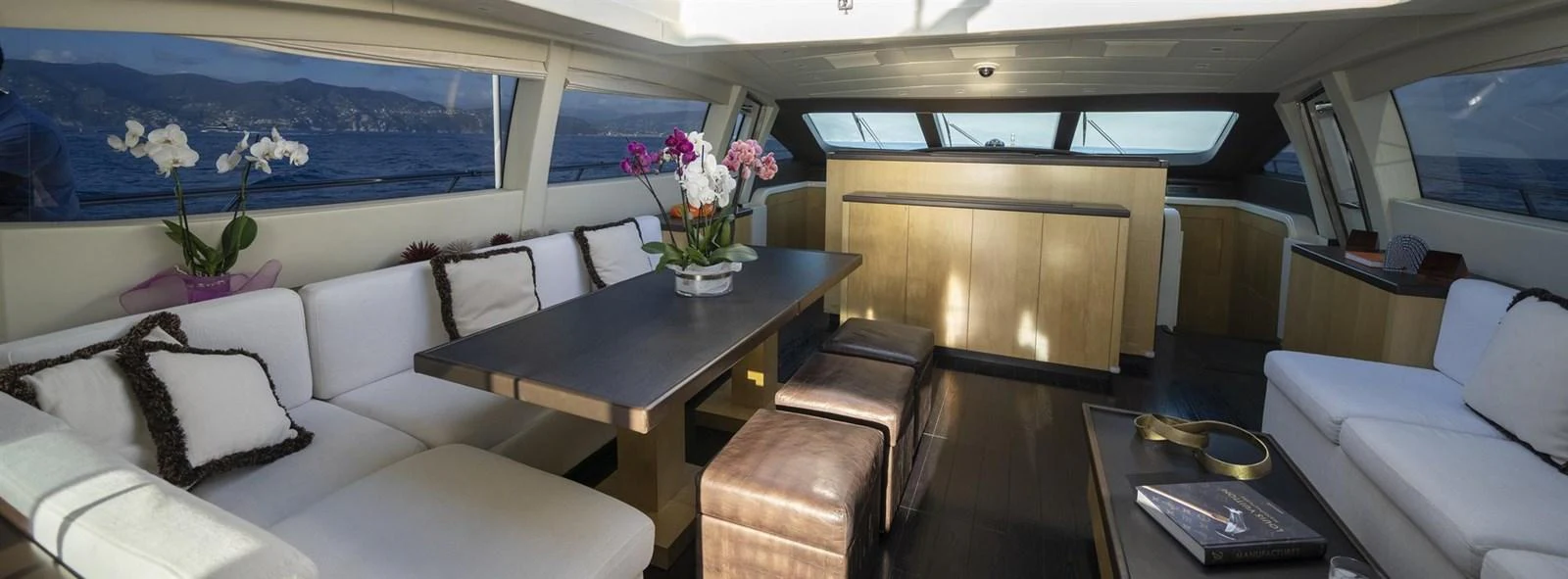 a room with a table and couches aboard MANU Yacht for Sale