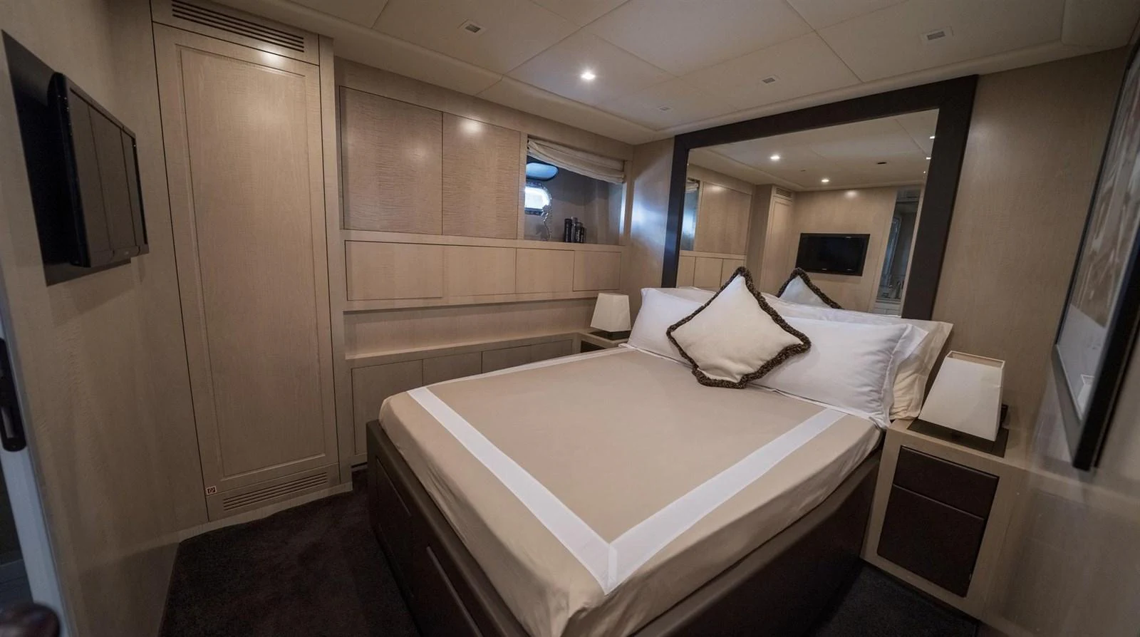 a room with a bed and a mirror aboard MANU Yacht for Sale
