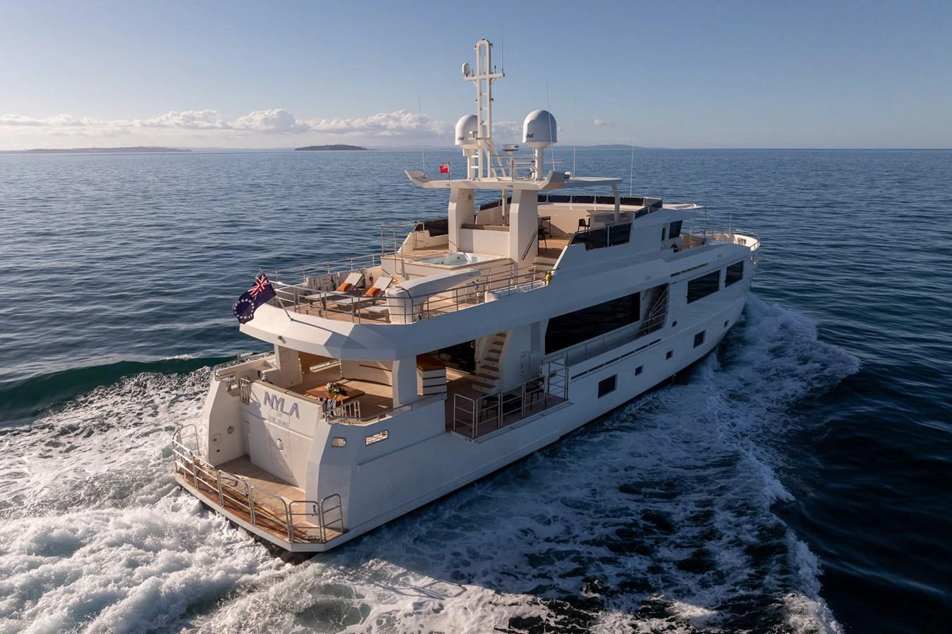 A luxurious yacht cruising on calm waters under a clear sky. aboard NYLA Yacht for Sale