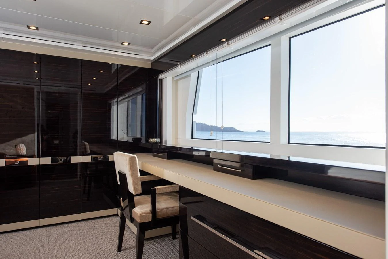 A sleek and modern interior space with a large window offering a stunning ocean view. aboard NYLA Yacht for Sale