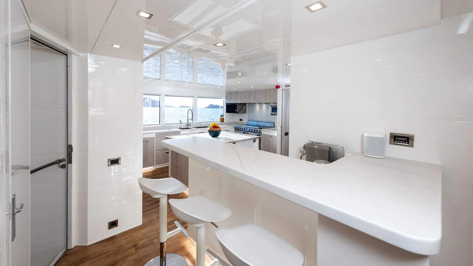 The yacht's galley features a sleek, modern design with ample counter space and seating. aboard NYLA Yacht for Sale