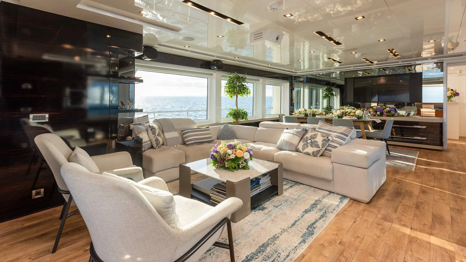 The yacht's salon offers a spacious and elegantly furnished area with ample seating and large windows providing stunning ocean views. aboard NYLA Yacht for Sale