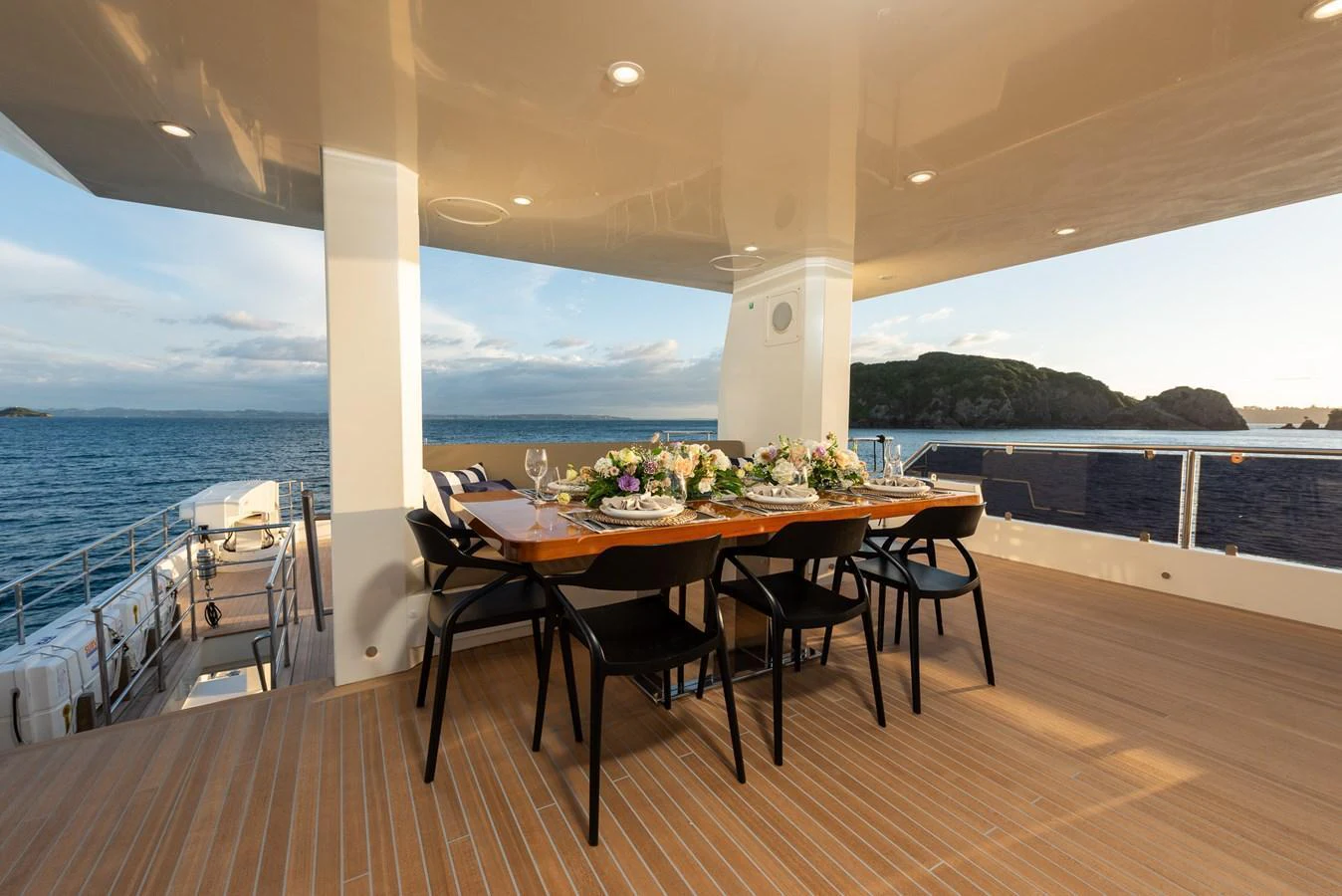 The aft deck features an elegant dining area with a stunning ocean view. aboard NYLA Yacht for Sale