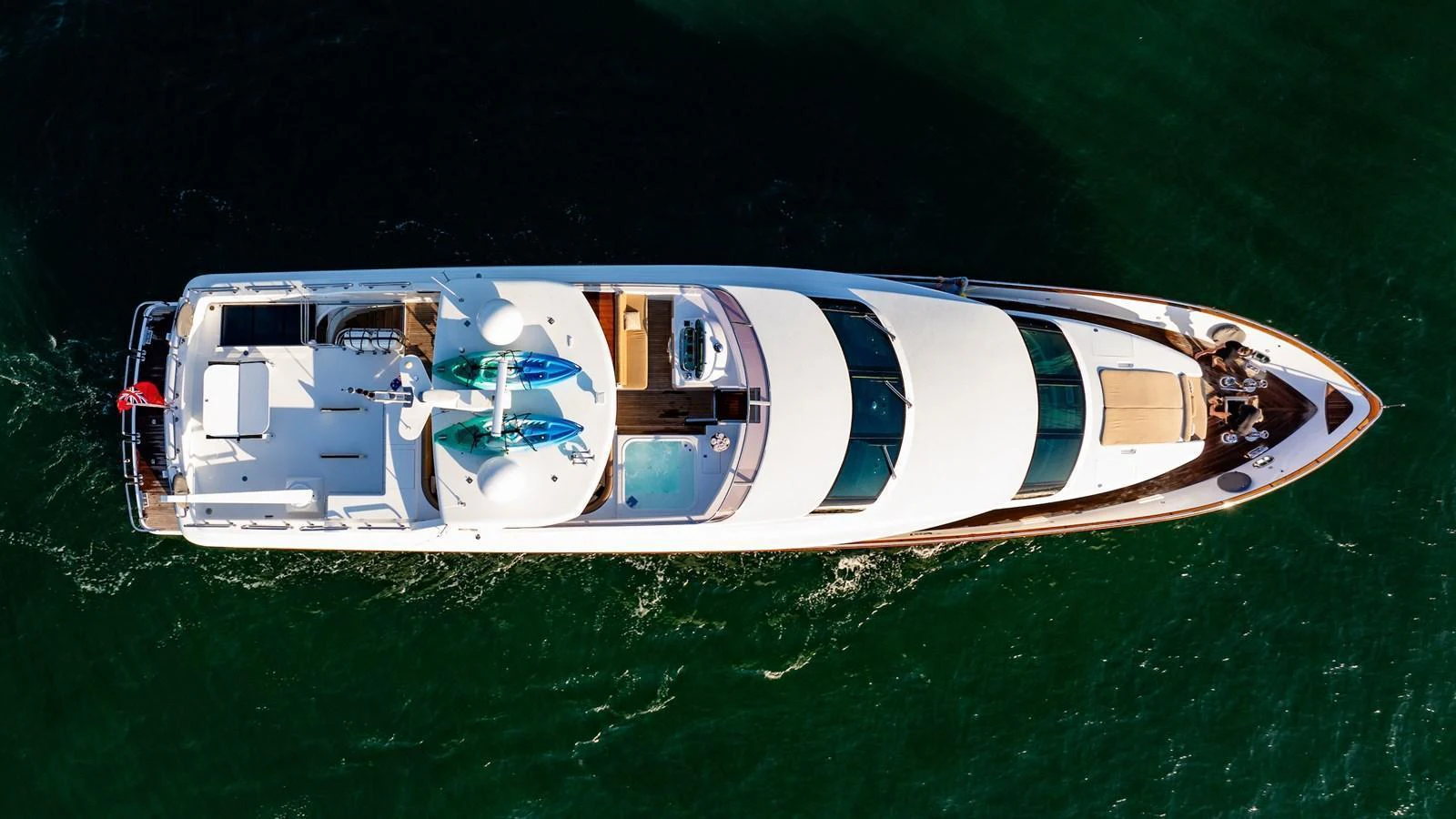 An aerial view of a sleek, modern yacht cruising through the water. aboard THE CLUBHOUSE Yacht for Sale