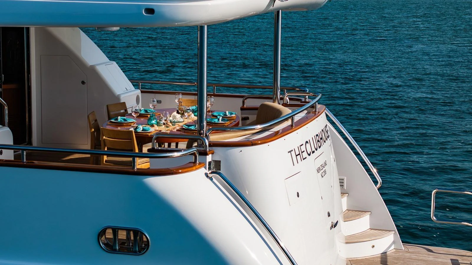 The aft deck features an elegant dining area with a stunning view of the sea. aboard THE CLUBHOUSE Yacht for Sale