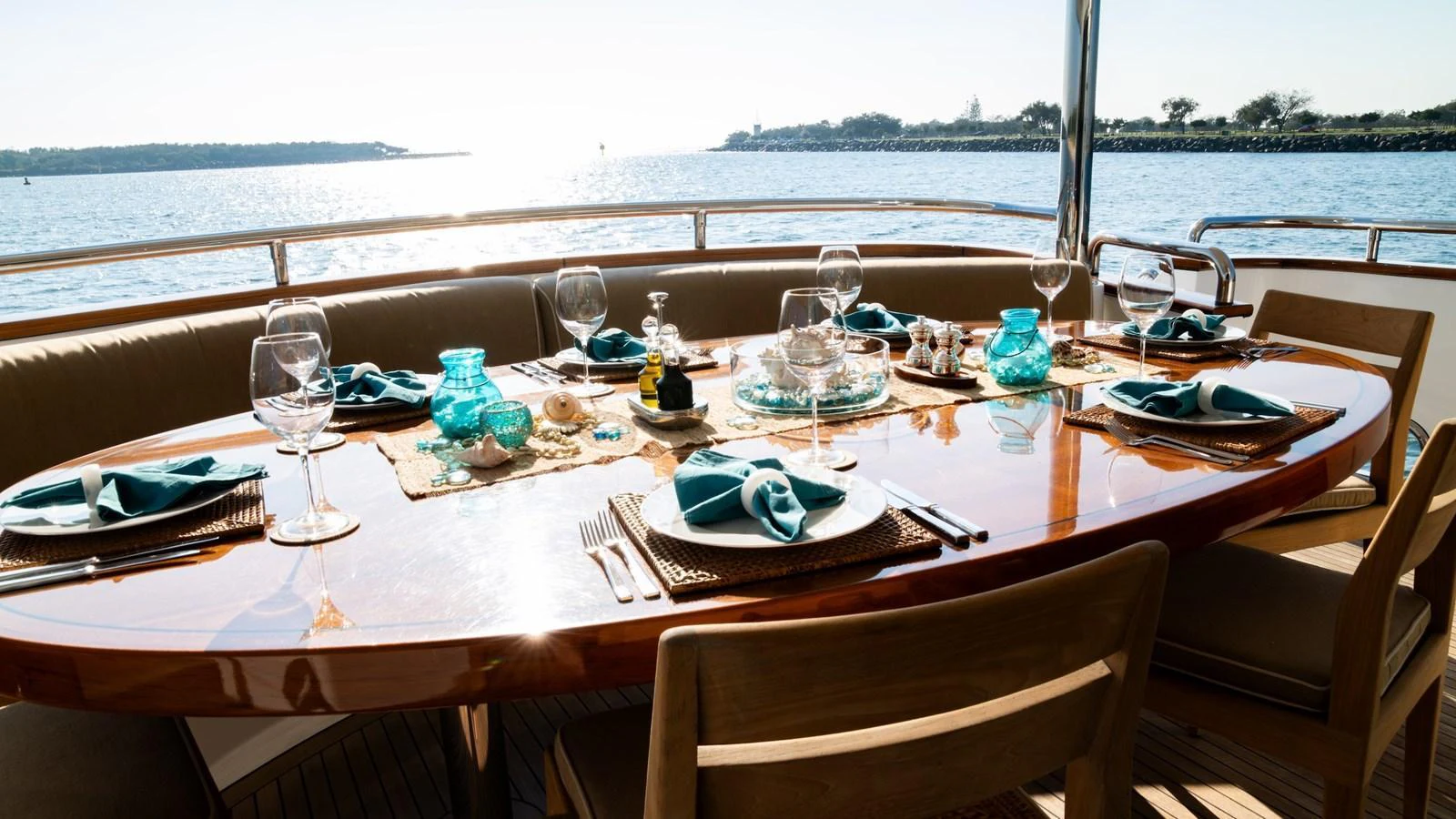 The aft deck features an elegant dining setup with a stunning view of the water. aboard THE CLUBHOUSE Yacht for Sale