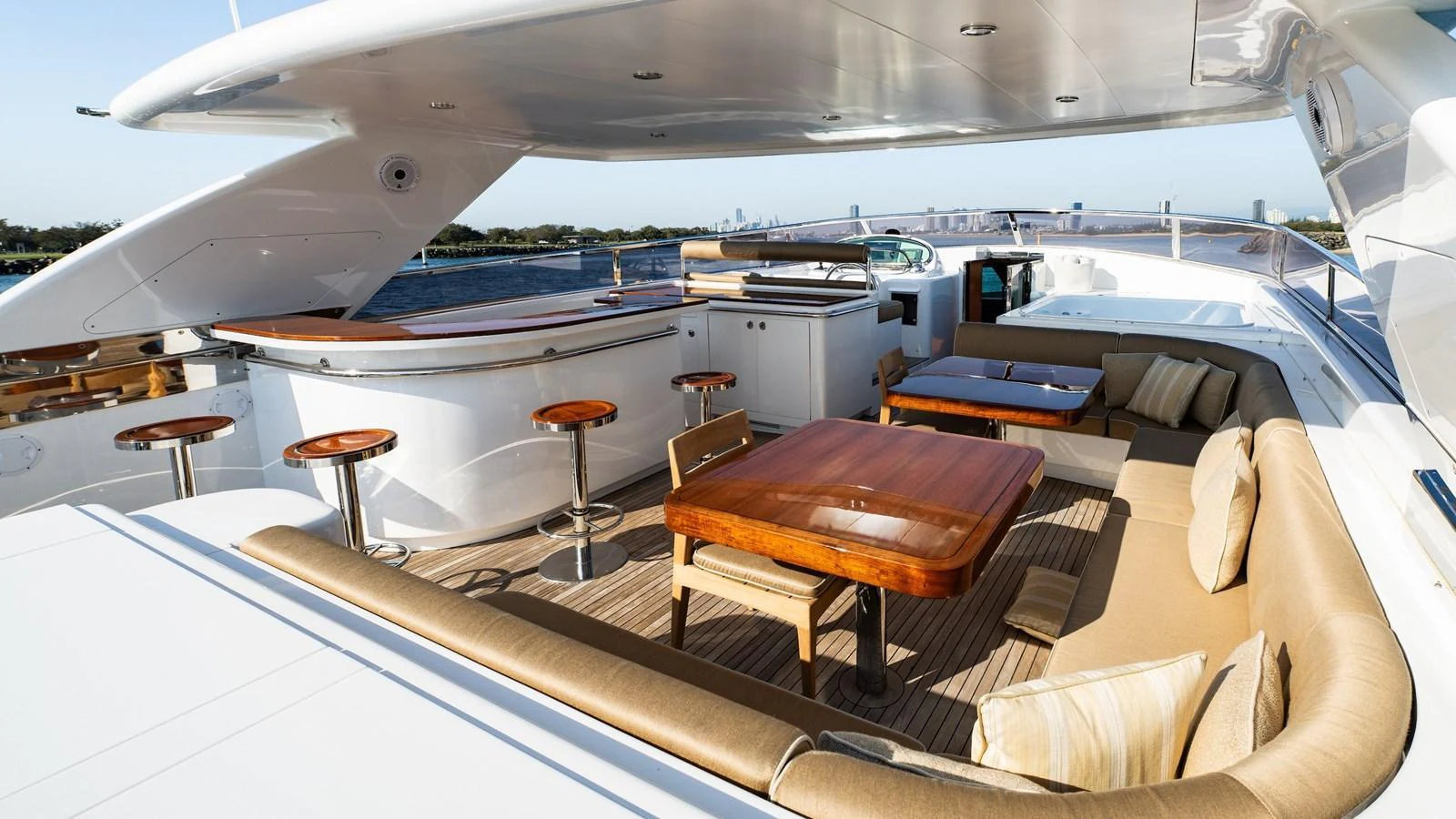 The flybridge offers a spacious and luxurious outdoor seating and dining area with a bar and panoramic views. aboard THE CLUBHOUSE Yacht for Sale