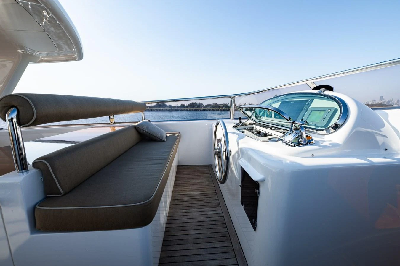 The yacht's helm area features a sleek design with a comfortable seating area and modern controls. aboard THE CLUBHOUSE Yacht for Sale