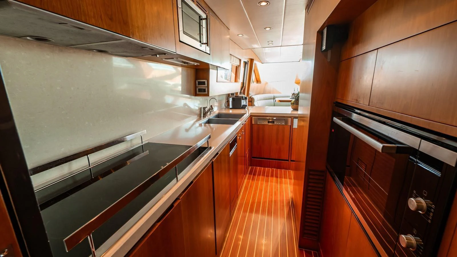 The yacht's galley features modern appliances and sleek wooden cabinetry, creating a stylish and functional space for meal preparation. aboard THE CLUBHOUSE Yacht for Sale