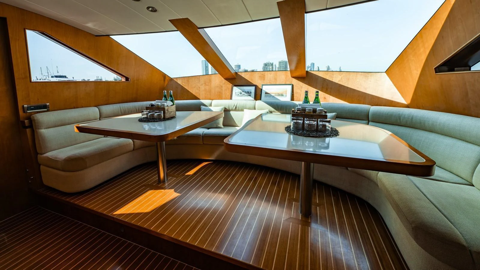 The yacht's interior features a spacious seating area with large windows providing ample natural light. aboard THE CLUBHOUSE Yacht for Sale