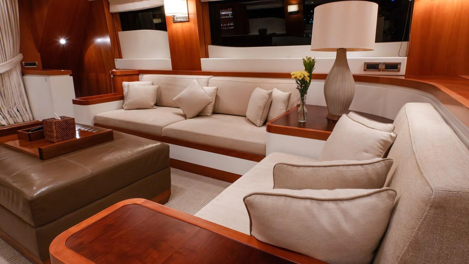 The salon features plush seating and elegant wooden accents, creating a warm and inviting atmosphere. aboard THE CLUBHOUSE Yacht for Sale