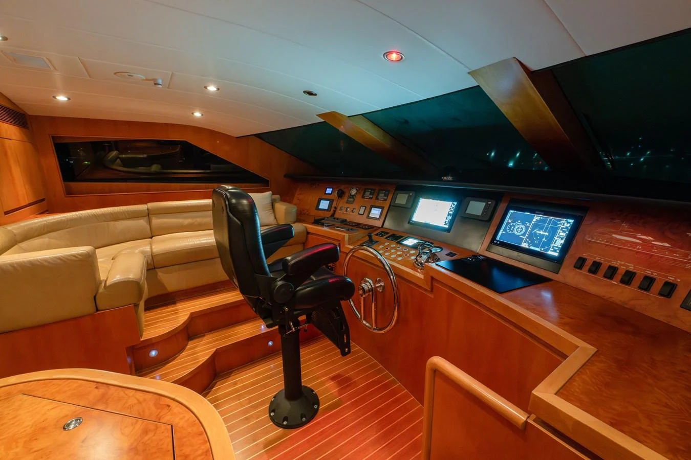 The helm features state-of-the-art navigation equipment and a comfortable seating area. aboard THE CLUBHOUSE Yacht for Sale