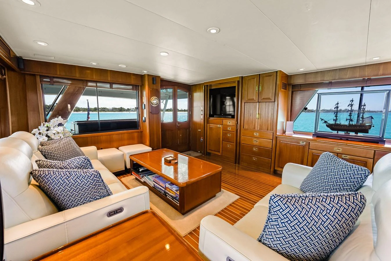 The salon features plush seating, a wooden coffee table, and large windows offering stunning sea views. aboard SERENITY Yacht for Sale
