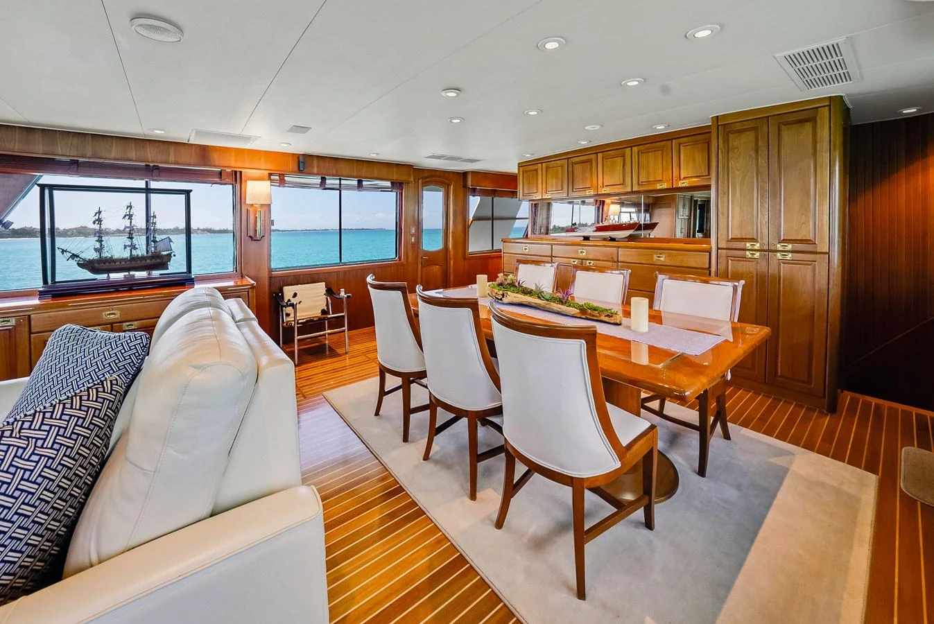 The yacht's dining area features elegant wooden furnishings and large windows offering stunning ocean views. aboard SERENITY Yacht for Sale