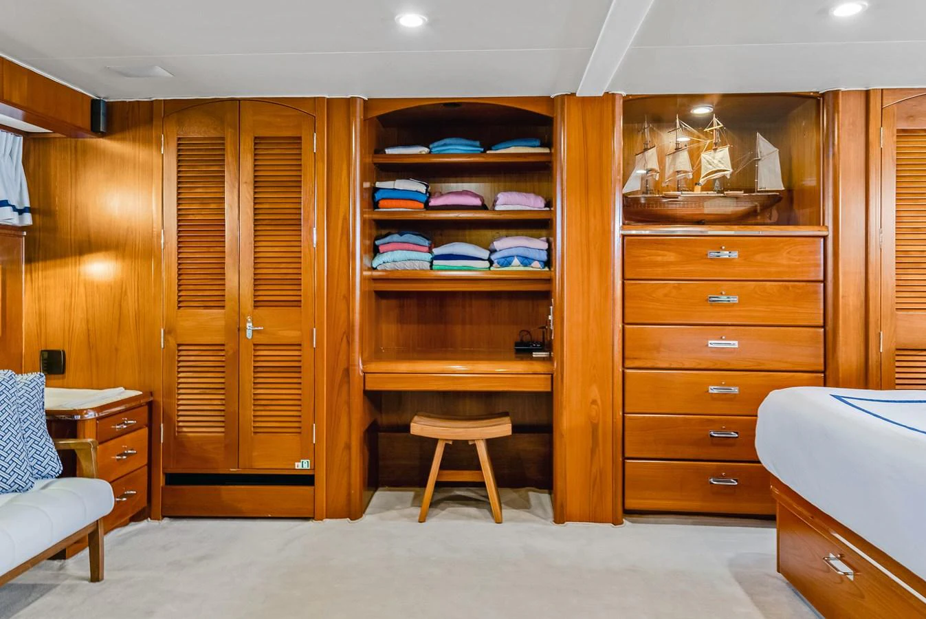 The stateroom features warm wooden cabinetry and a cozy seating area, creating a welcoming atmosphere. aboard SERENITY Yacht for Sale