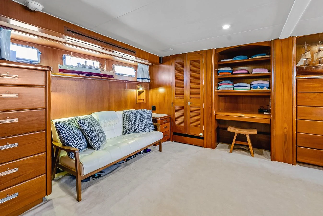 The yacht's interior features a cozy seating area with ample storage and a workspace. aboard SERENITY Yacht for Sale