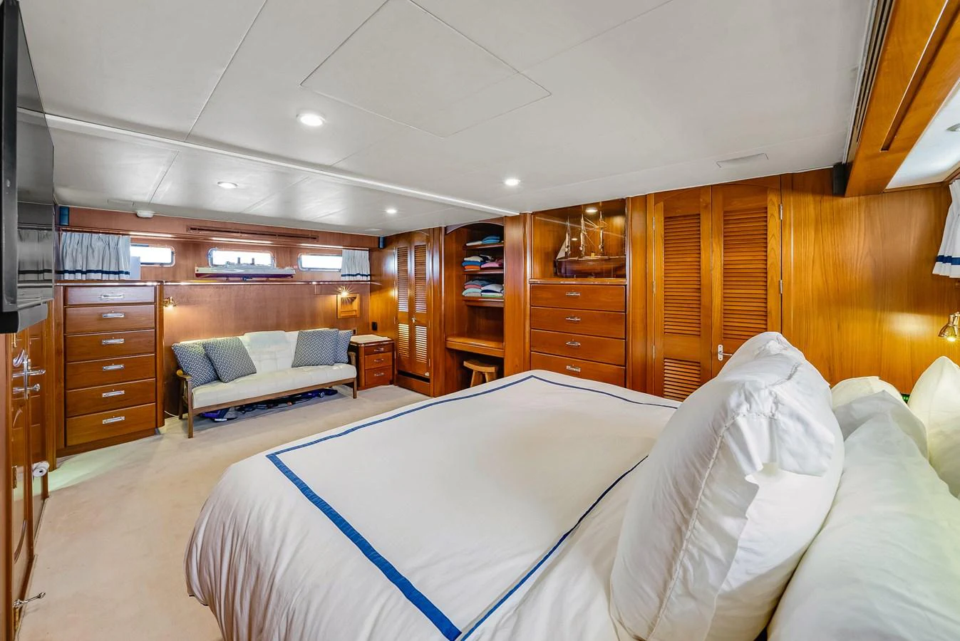 The master stateroom features a spacious bed, ample storage, and elegant wood finishes. aboard SERENITY Yacht for Sale