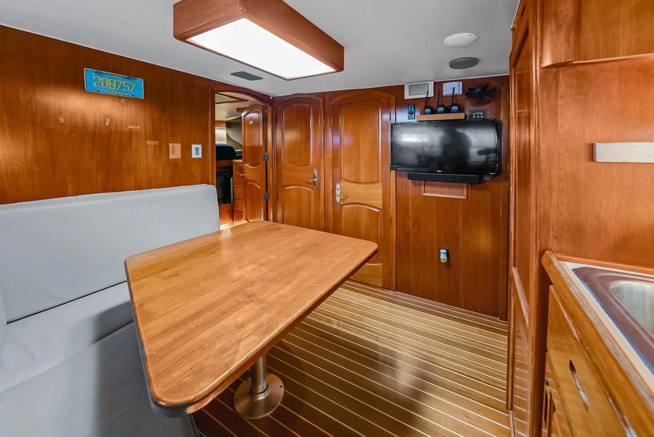 The yacht's interior dining area features a wooden table, comfortable seating, and modern amenities. aboard SERENITY Yacht for Sale