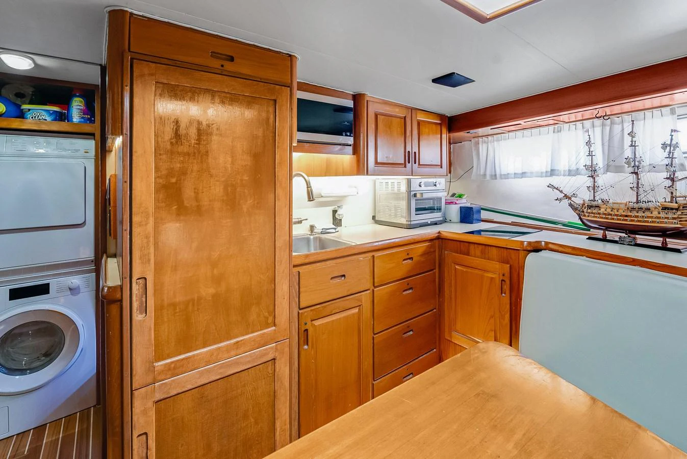 The galley features wooden cabinetry, modern appliances, and a cozy dining area. aboard SERENITY Yacht for Sale