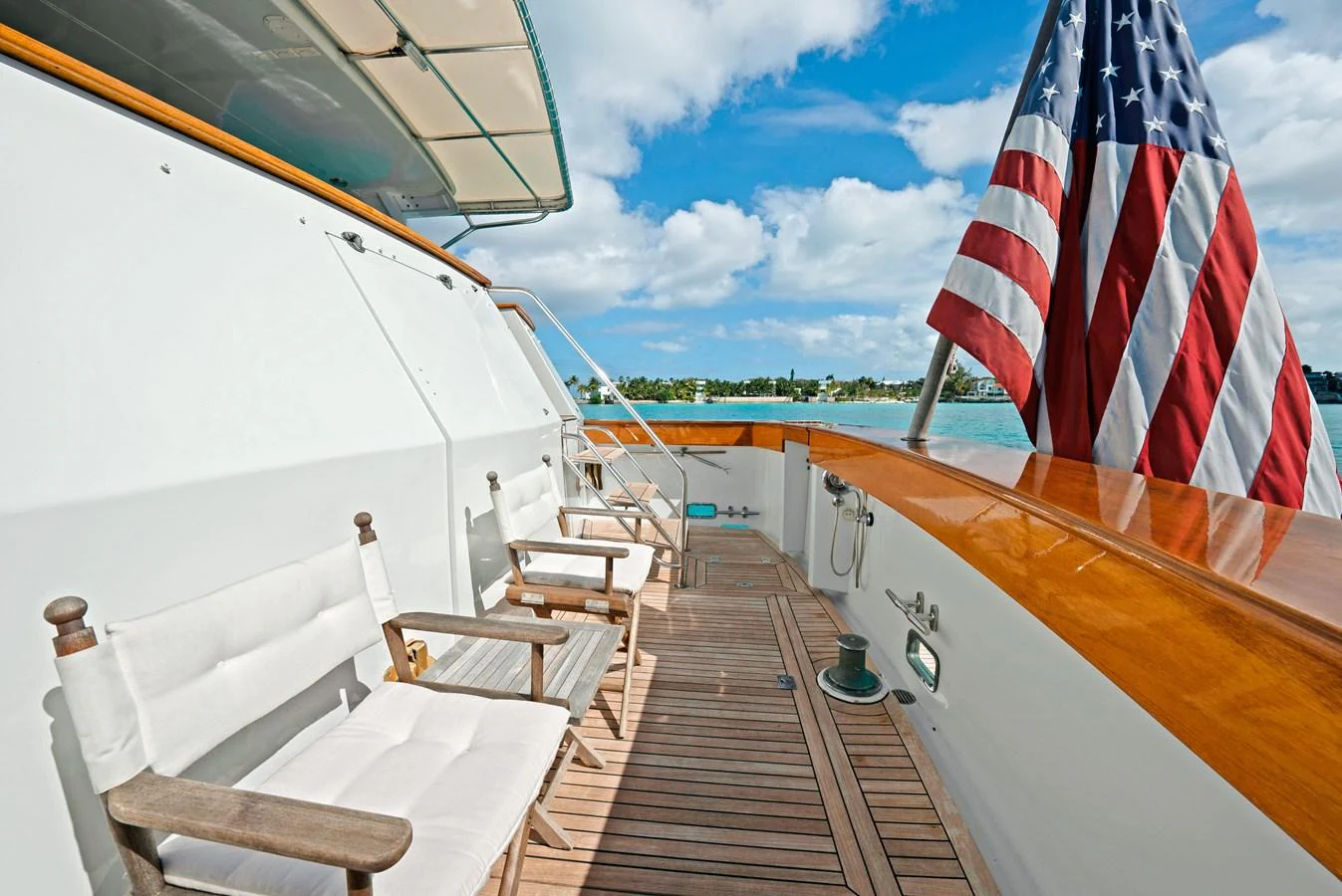 The aft deck features comfortable seating with a view of the water and an American flag waving in the breeze. aboard SERENITY Yacht for Sale