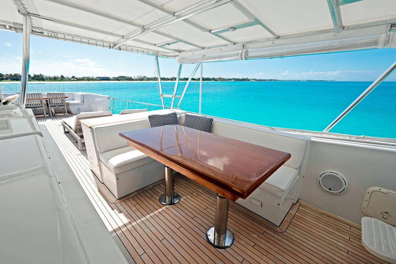 The aft deck offers a spacious and shaded dining area with stunning ocean views. aboard SERENITY Yacht for Sale