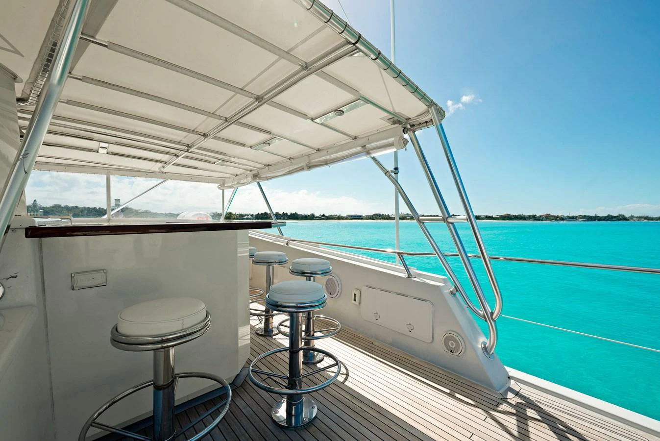 The flybridge offers a shaded bar area with stunning views of the turquoise waters. aboard SERENITY Yacht for Sale