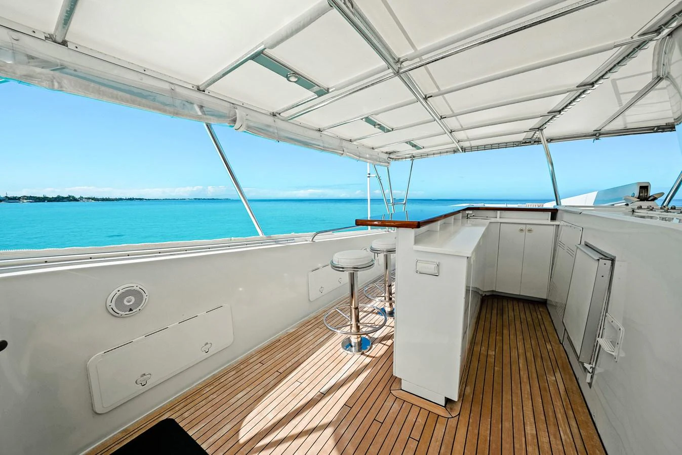 The flybridge offers a spacious and shaded area with a bar and seating, perfect for enjoying the ocean views. aboard SERENITY Yacht for Sale