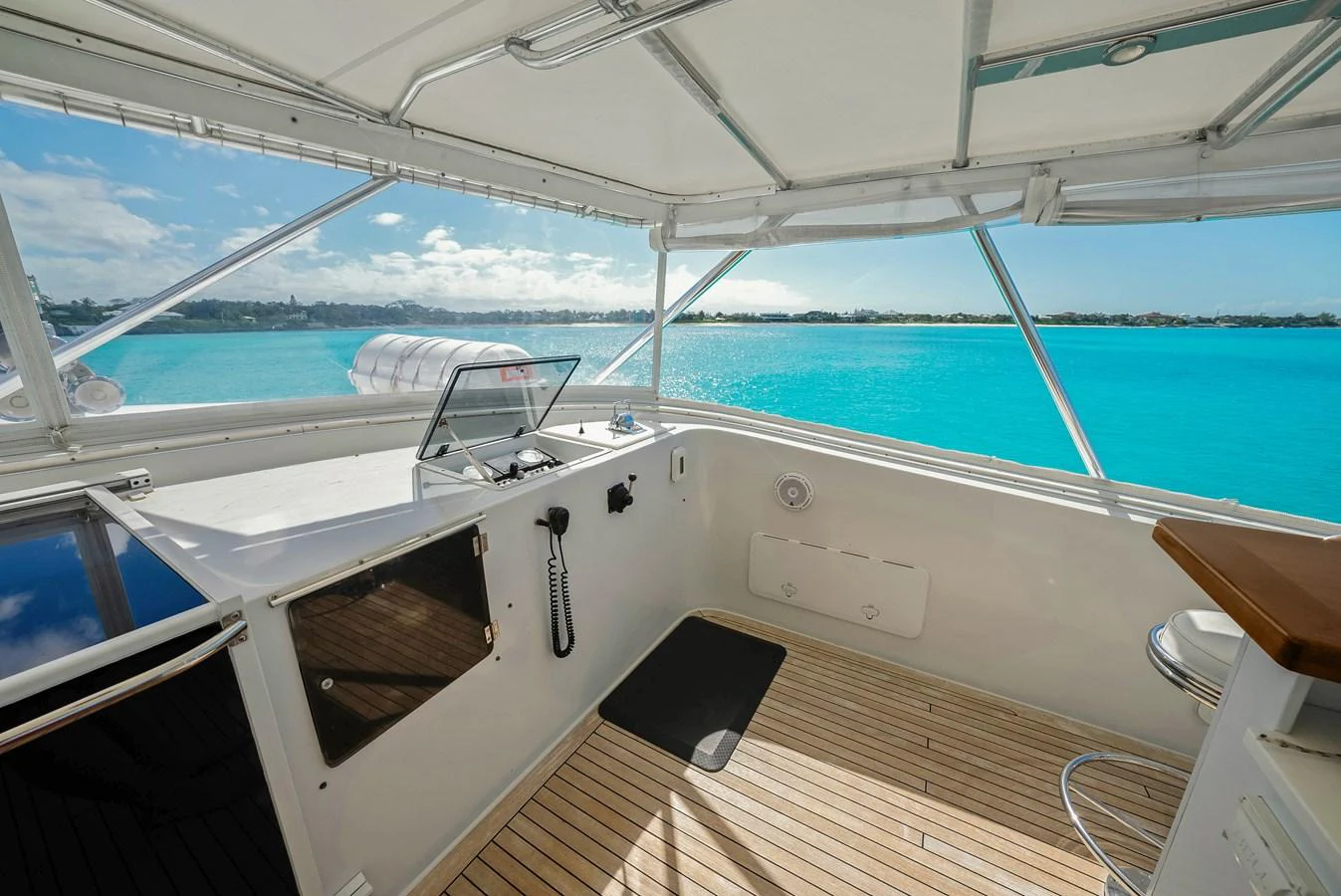 The helm station offers a panoramic view of the turquoise waters, combining functionality with serene beauty. aboard SERENITY Yacht for Sale