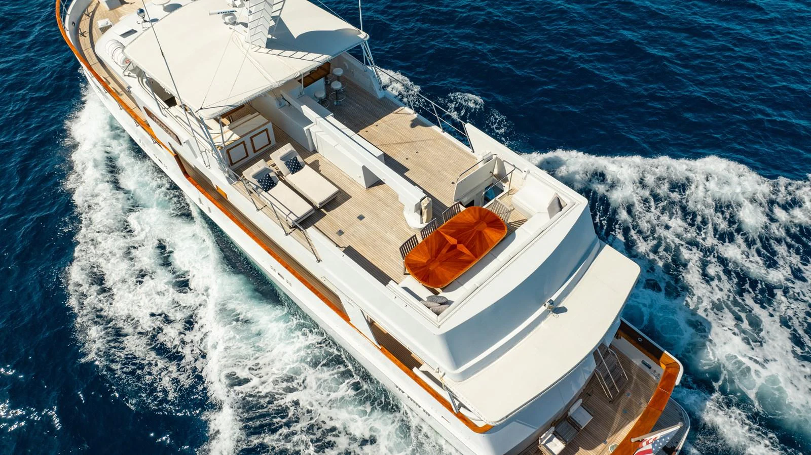 The yacht glides through the water, showcasing its spacious aft deck and sleek design. aboard SERENITY Yacht for Sale