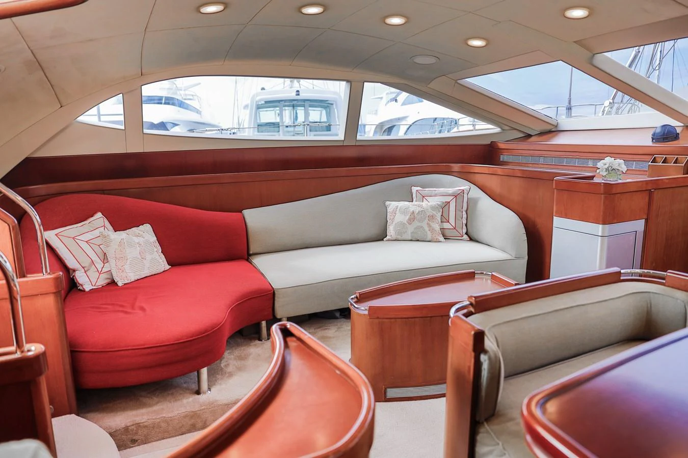 The salon features a stylish and comfortable seating area with large windows offering a view of the marina. aboard GOLDEN TOUCH Yacht for Sale