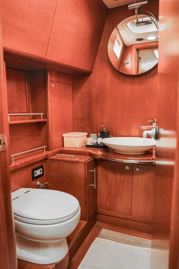The yacht's head features elegant wooden cabinetry and modern fixtures, creating a warm and inviting space. aboard GOLDEN TOUCH Yacht for Sale