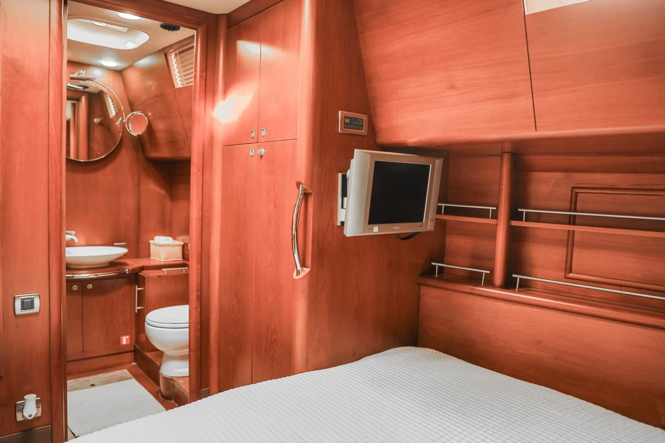 The cozy stateroom features warm wood finishes and a compact ensuite bathroom. aboard GOLDEN TOUCH Yacht for Sale