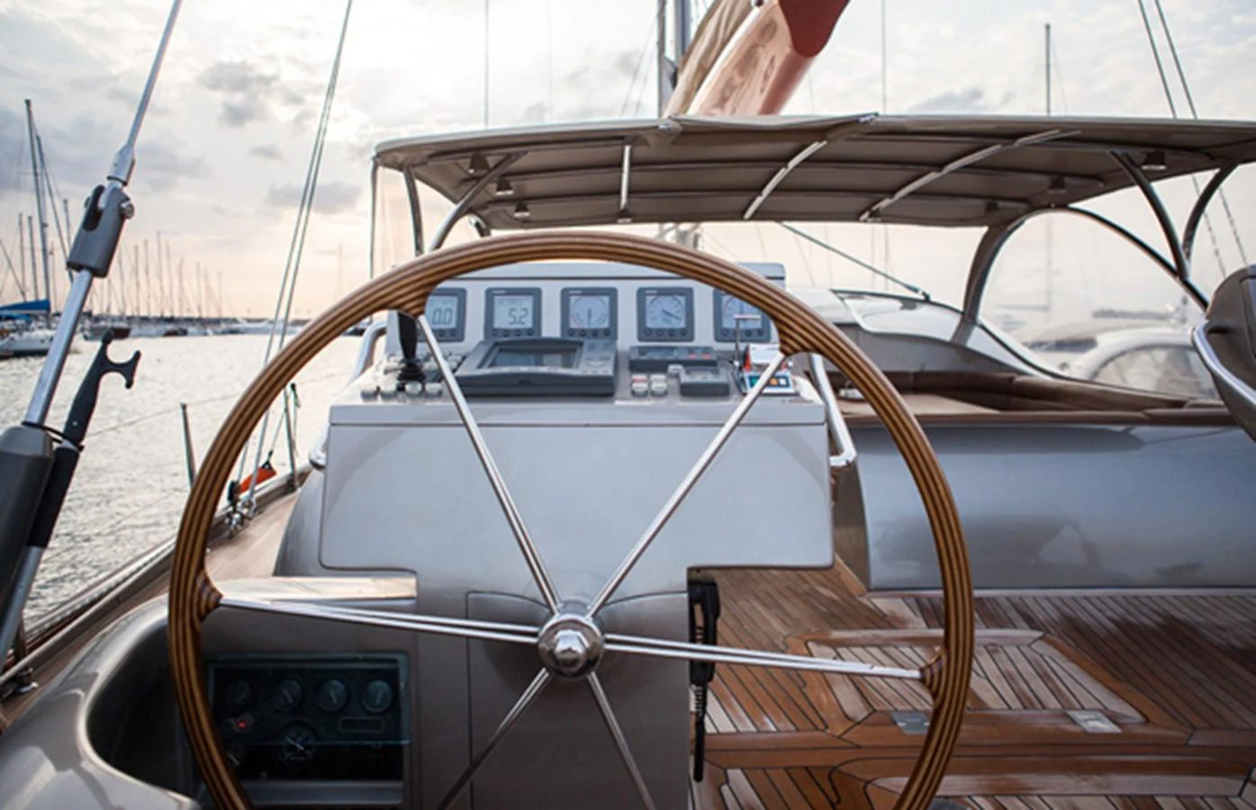 The helm station features a sleek design with modern navigation instruments and a classic wooden steering wheel. aboard GOLDEN TOUCH Yacht for Sale